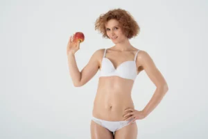 A woman framing her midsection with her hands to illustrate what is Umbilicus Reconstruction and the aesthetic restoration of the navel area.