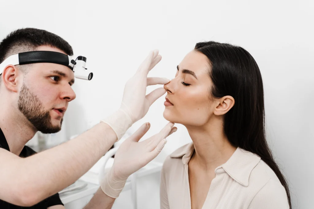 A clinical consultation where a specialist evaluates a patient's nasal bridge to determine if they are a good candidate for Septoplasty.
