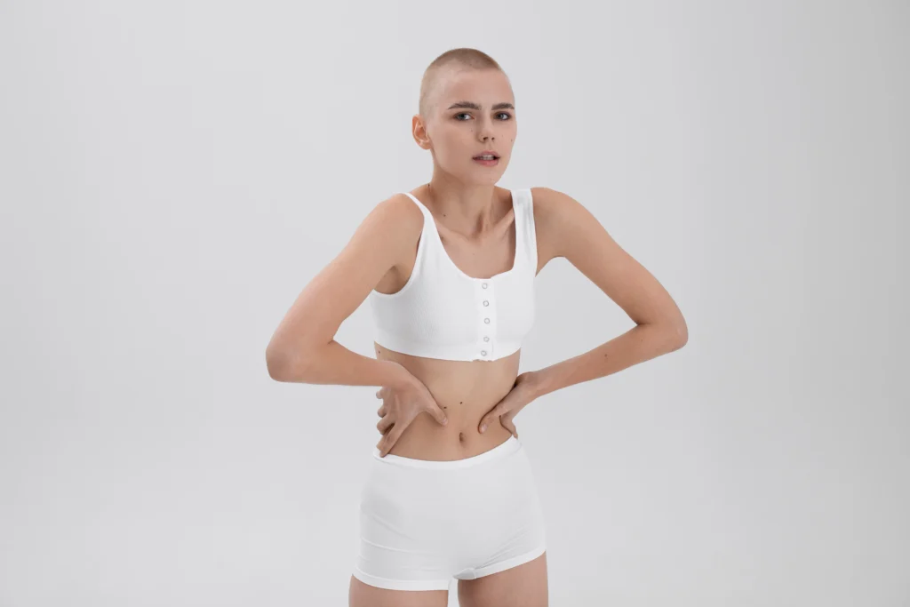 A woman holding her stomach to highlight the midsection, representing a patient seeking Umbilicus Reconstruction after weight loss.