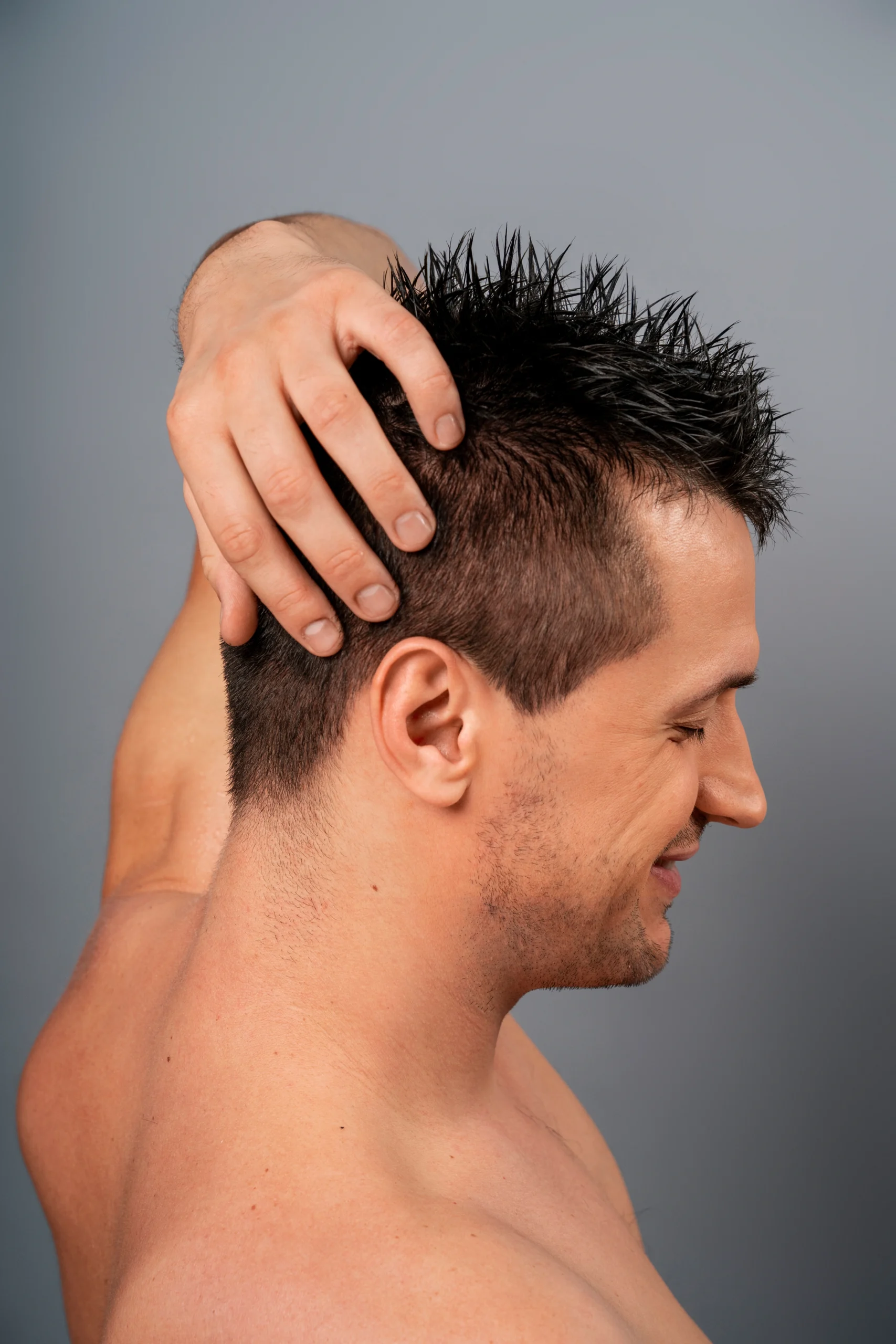 Side profile of a man inspecting his scalp and hair density for a hair transplant in Dubai.