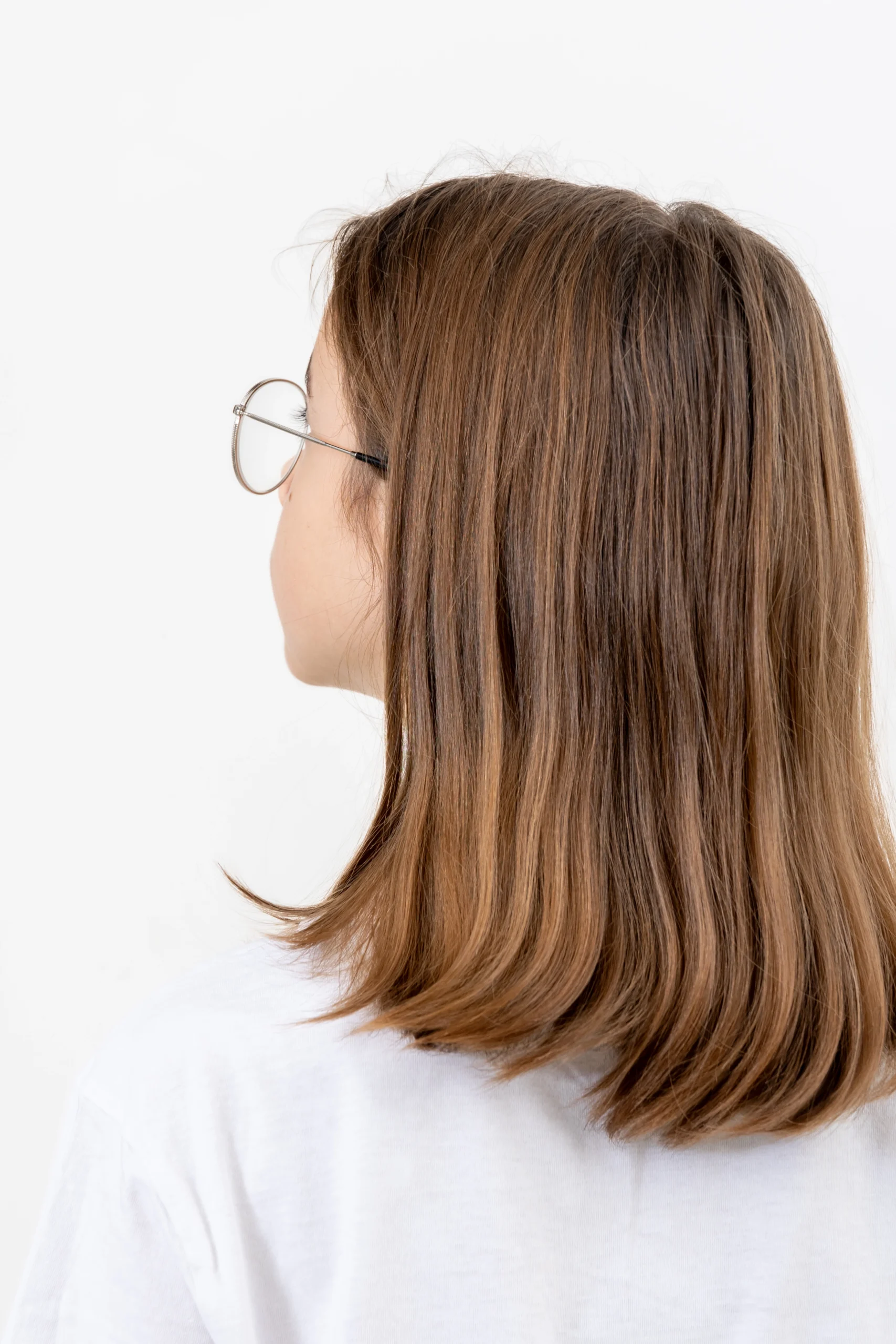 Rear view of a woman with healthy brown hair, illustrating the donor and recipient areas for a hair transplant in Dubai.