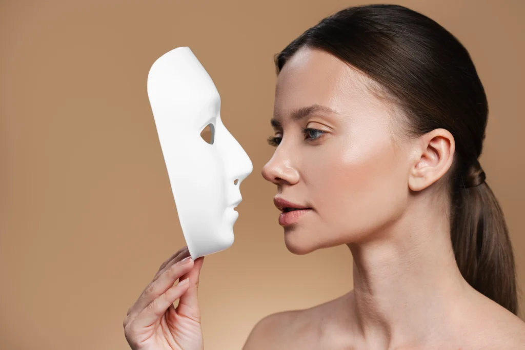 A profile view of a patient comparing her nasal structure to a mask, illustrating the importance of realistic expectations for a good candidate for Rhinoplasty in Dubai.