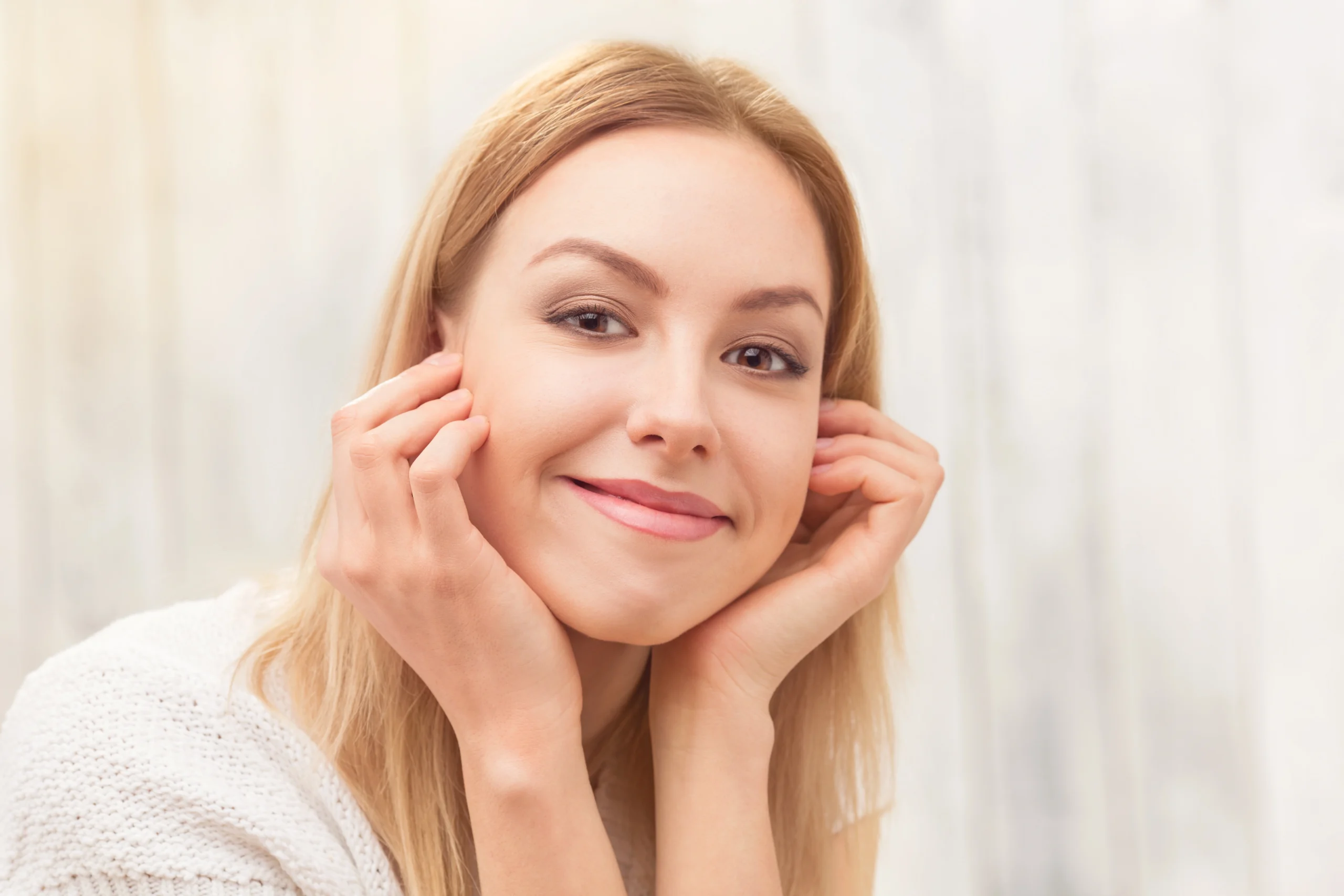 A female patient smiling with restored facial symmetry, firmer cheek contours, and a defined jawline following a natural facelift procedure by Dr. Sanjay Parashar.